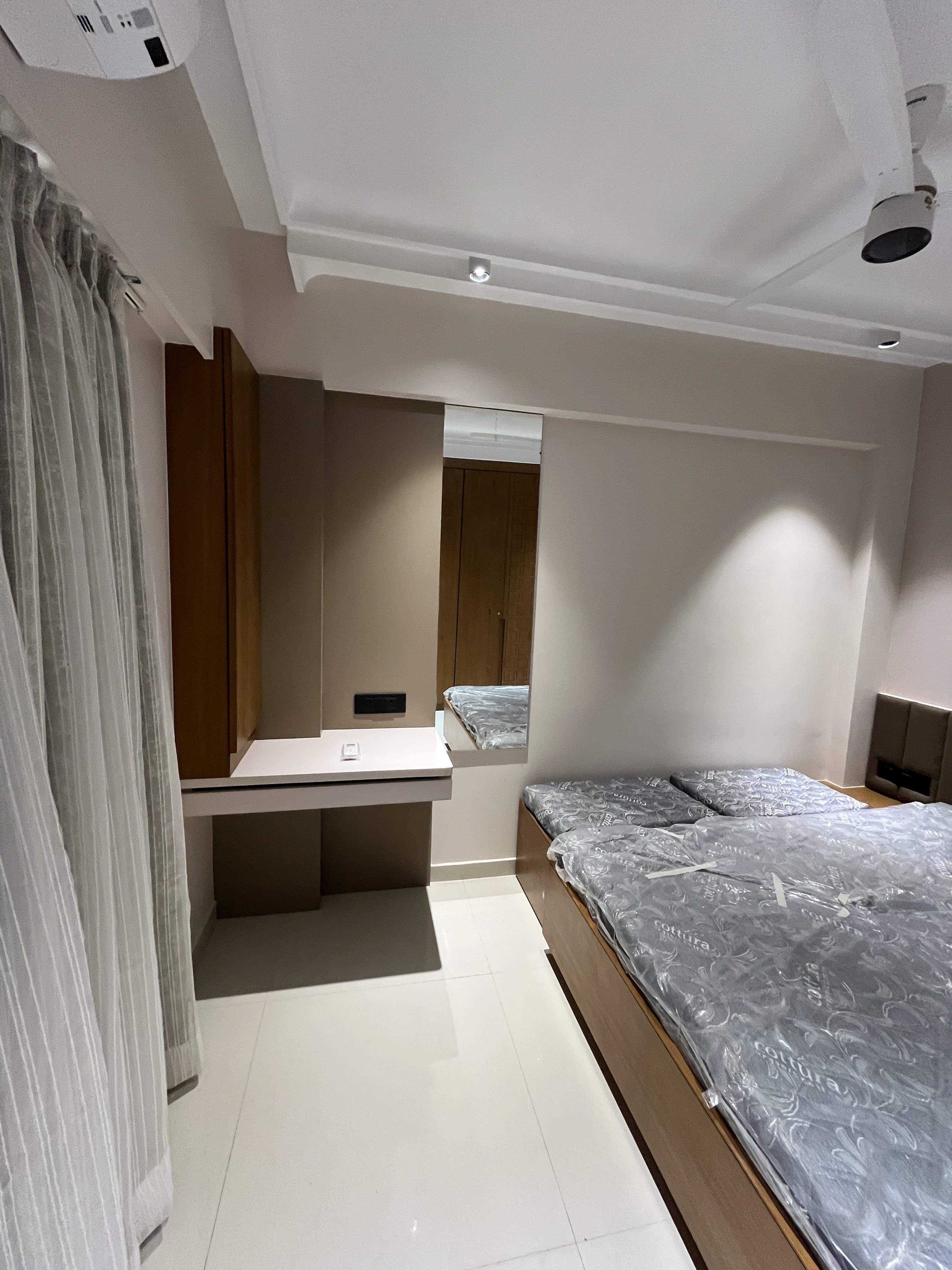 Bedroom with built-in dressing nook, mirrored vanity and warm lighting by BR Interiors
